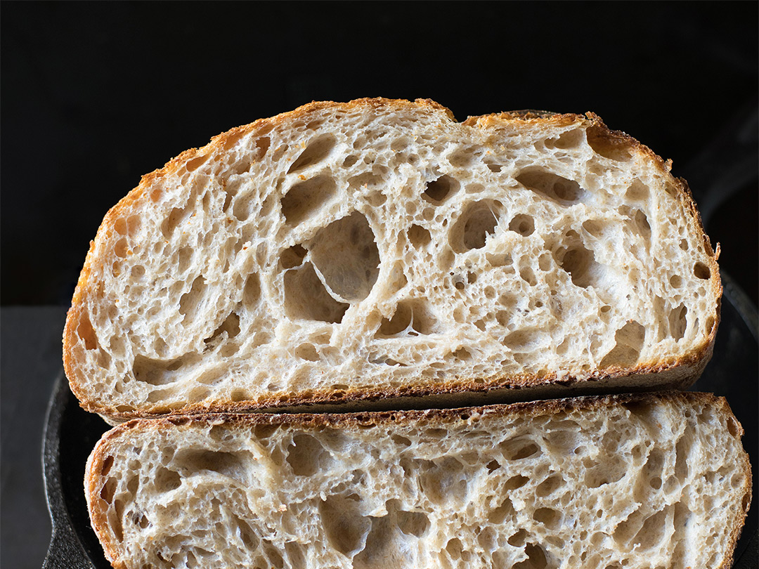 A loaf of sourdough bread in a bread box.